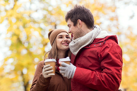 爱,关系,季节人的快乐的轻夫妇带着咖啡杯秋天的公园散步图片