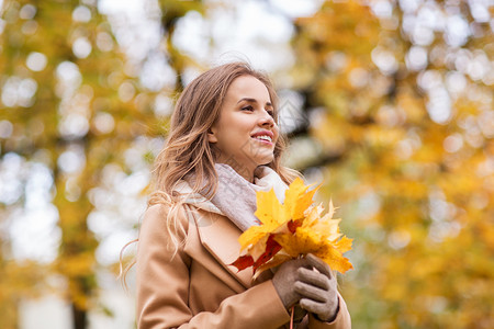 季节人的美丽的轻女人带着枫叶走秋天的公园里秋天公园里枫叶的漂亮女人图片