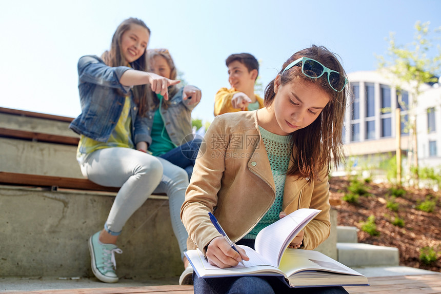 教育,欺凌,高中,社会关系人的快乐的学生女孩与书中的同学遭受嘲弄学生女孩遭受同学嘲笑图片