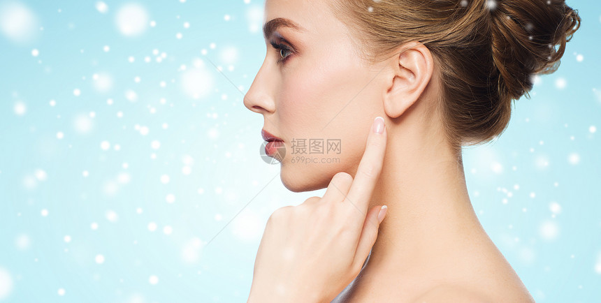 健康,人,冬天美丽的靠近美丽的轻女人指着她的耳朵蓝色的背景雪图片