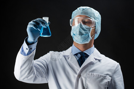 科学,化学,研究人的轻的科学家保护具,帽子护目镜持测试瓶与化学黑色背景图片