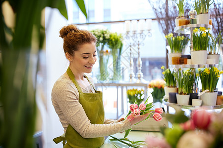 人,商业,销售花卉快乐微笑的花店妇女花店制作郁金香图片