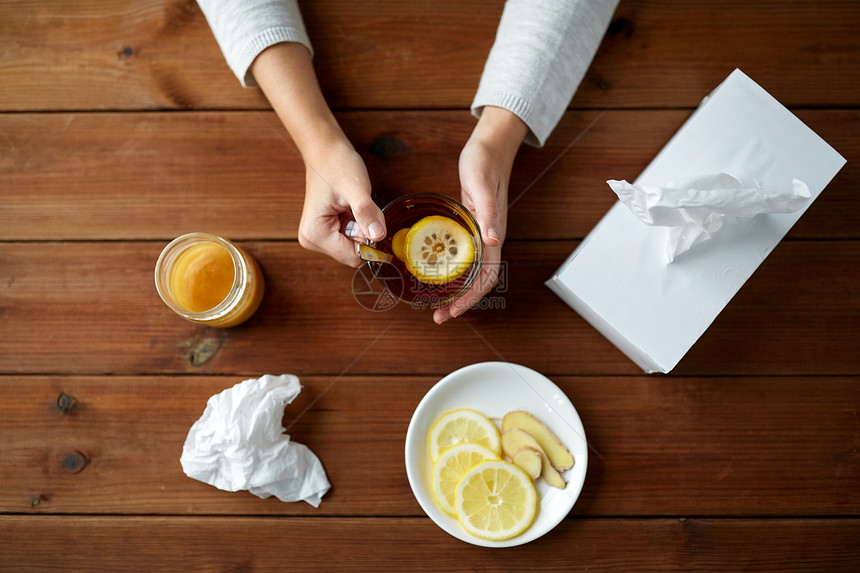 健康,传统医学民族科学生病的女人喝茶与柠檬,蜂蜜生姜纸巾盒木桌上图片