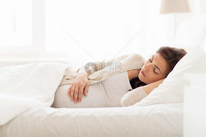 怀孕,休息,人期望的快乐的孕妇睡家里的床上图片