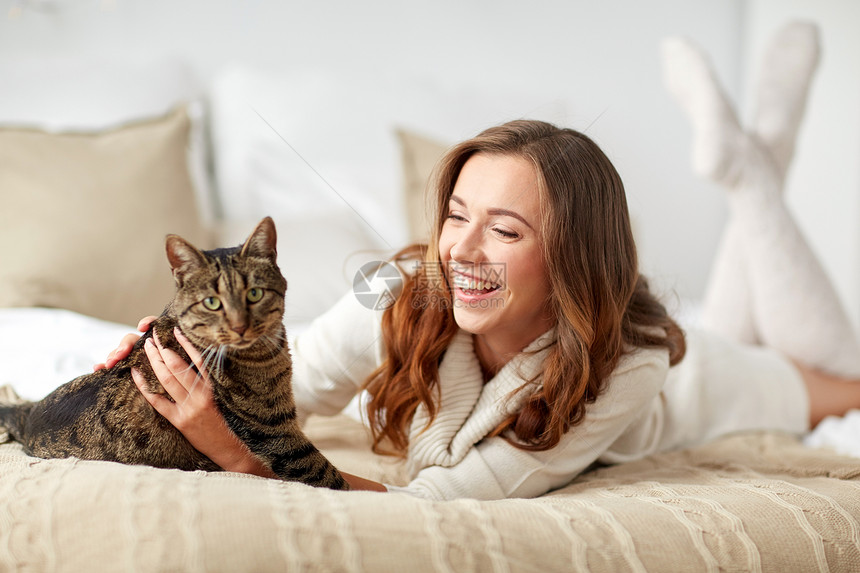 宠物,舒适,休息人的快乐的轻女人猫躺床上家图片