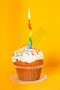 黄色餐巾纸上支燃烧的蜡烛的纸杯蛋糕带蜡烛的纸杯蛋糕图片