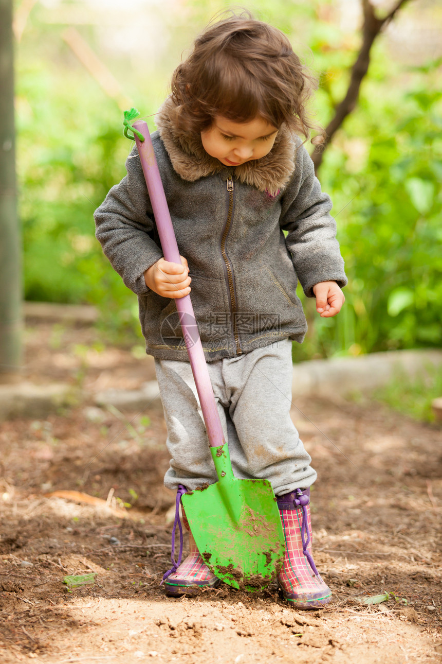 穿着橡胶靴的小女孩着铲子想挖着小铲子的小女孩图片