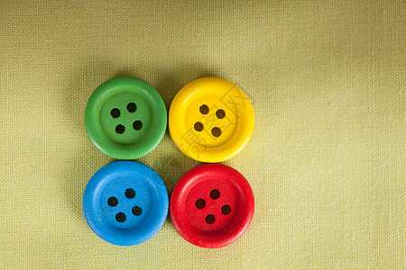 五颜六色的纽扣绿色纺品上特写五颜六色的纽扣图片