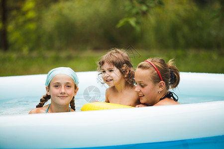 三个女孩蓝色的游泳池里游泳游泳池里的女孩图片