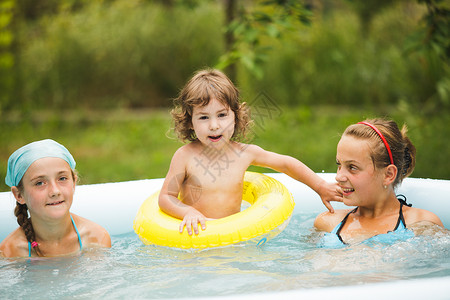 三个女孩蓝色的游泳池里游泳,玩球游泳池里的女孩图片
