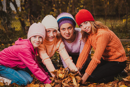 四个女孩玩秋叶,笑着女孩们玩树叶图片