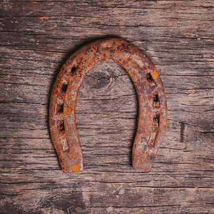 木制背景上的特写旧生锈的马蹄铁马蹄铁为了好运背景图片