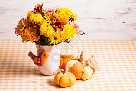 桌子上花小橙色纺南瓜的花瓶秋天的装饰高清图片