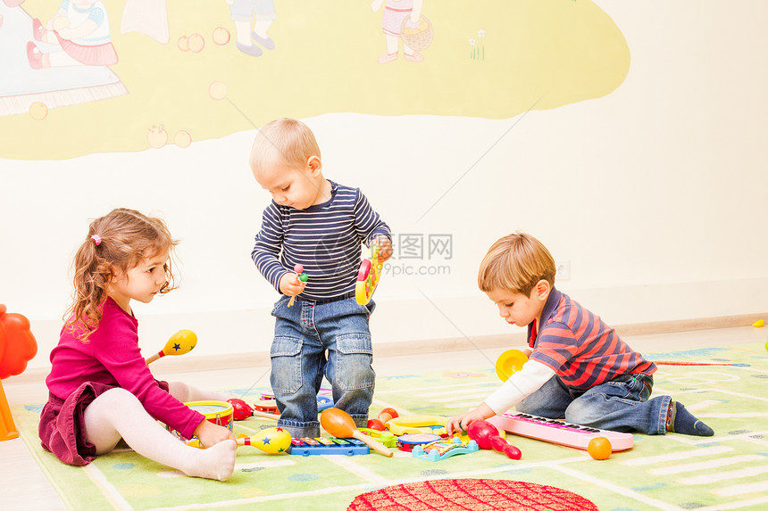 三个孩子游戏室里玩孩子们幻想他们音乐家女孩打鼓,个男孩弹琴,个男孩弹钢琴图片