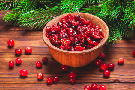 红色树枝素材蔓越莓干放木碗冷杉树枝上小红莓干碗里背景
