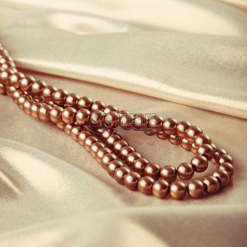 丝绸纺品上珠子的背景丝绸上的珠子图片