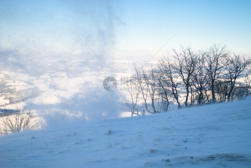 雪覆盖着被风过的山峰远处的座木屋山上的雪风图片