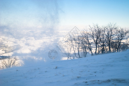 雪覆盖着被风过的山峰远处的座木屋山上的雪风图片