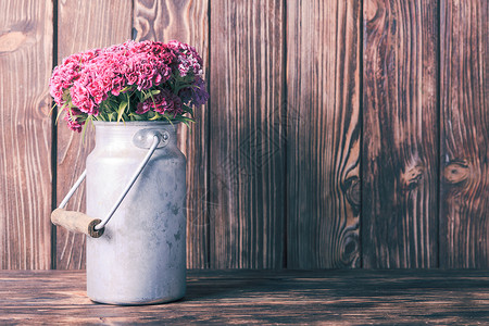 粉红色康乃馨个老式的锡罐木制背景乡村装饰图片