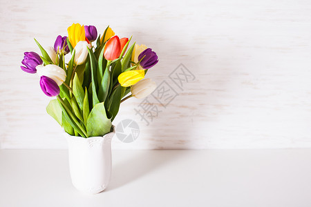 白色花瓶里的彩色郁金香的弹簧花瓶里的彩色郁金香图片