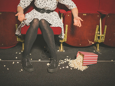个轻的女人电影院里把爆米花洒地板上感安图片