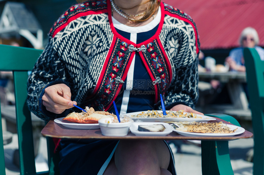 个轻的女人阳光明媚的日子里外吃可乐熏鱼图片