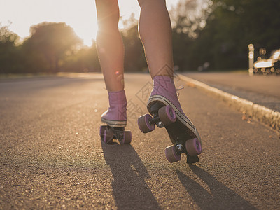 个轻女人的腿,因为她轮滑公园日落图片