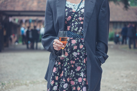 个轻的女人穿着件男人的夹克她的衣服上站着,农村的个聚会上喝酒图片