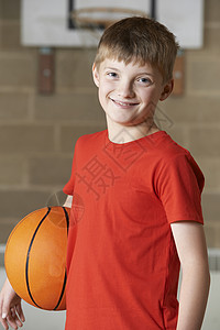 学校体育馆里篮球的男孩的肖像图片