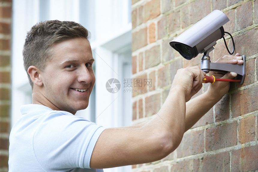 安全顾问将安全摄像头安装房屋墙壁上图片