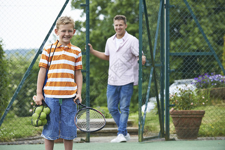 父亲送儿子上网球课高清图片
