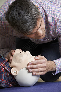 急救的人CPR假人上检查气道图片