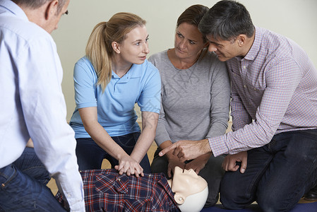 妇女示范CPR训练假人急救课背景图片