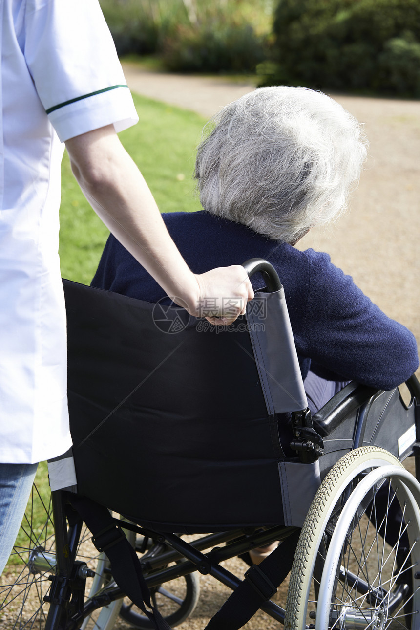 特写护理人员推着轮椅的老年女子图片