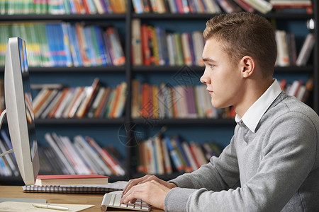 图书馆电脑工作的男青少学生图片
