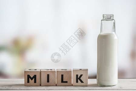 牛奶瓶木制桌子上的牛奶词图片