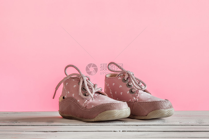 木制桌子上粉红色的婴儿鞋图片