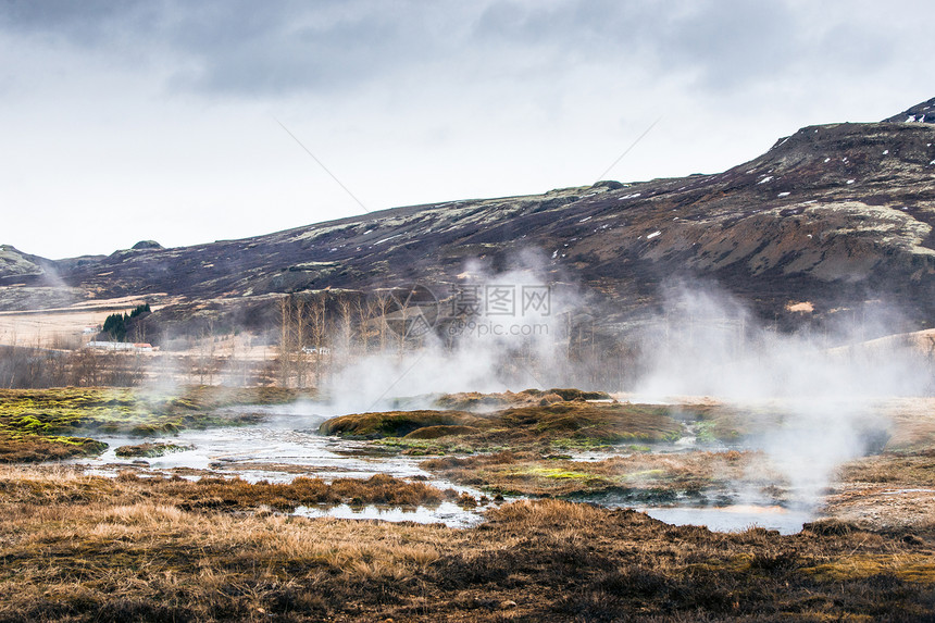 冰岛座山下的薄雾沼泽地热活动图片