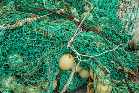 港口边凌乱的绿色渔网图片