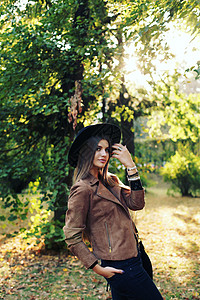 街头时尚个漂亮女孩的特写肖像戴着帽子绒夹克着带条纹的包美丽的秋姑娘背景图片