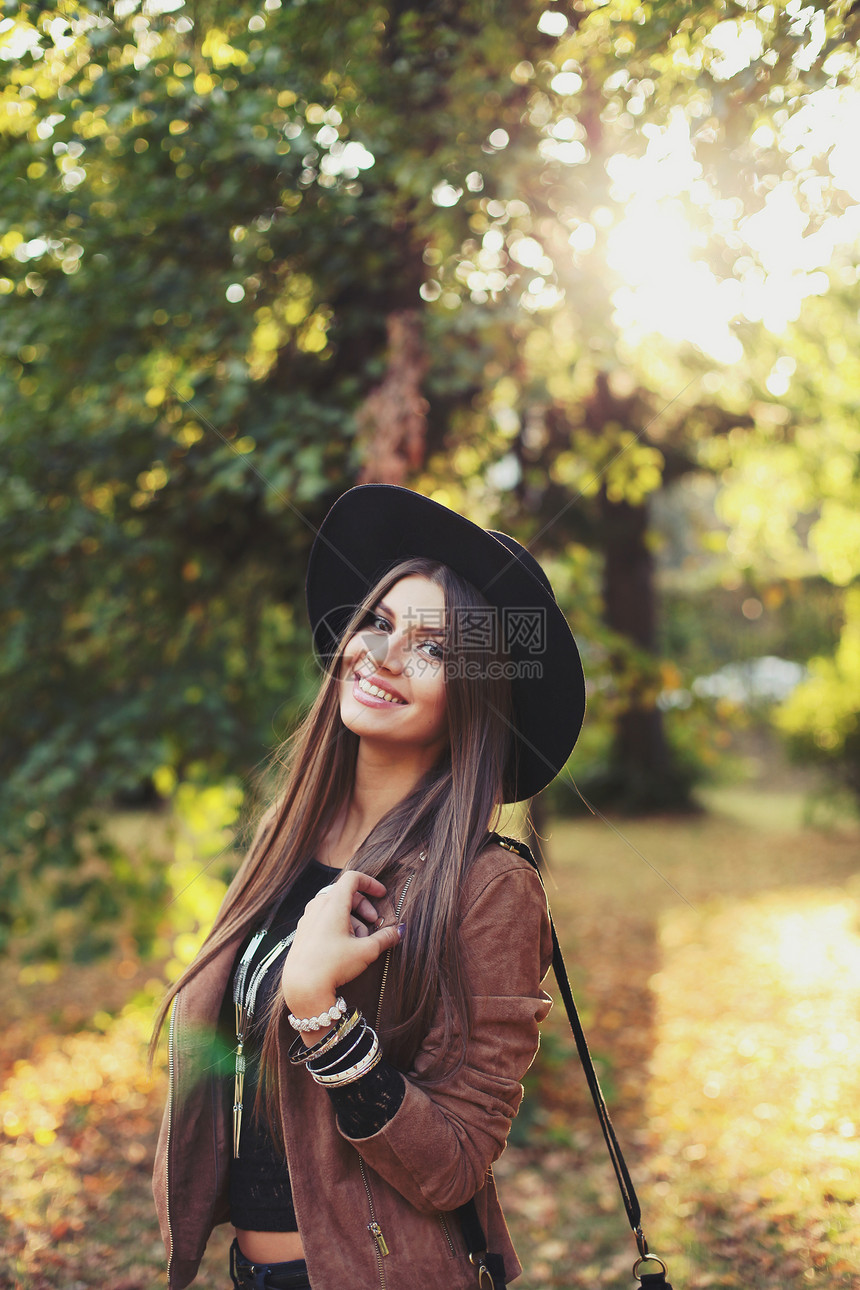 街头时尚个漂亮女孩的特写肖像戴着帽子绒夹克着带条纹的包美丽的秋姑娘图片