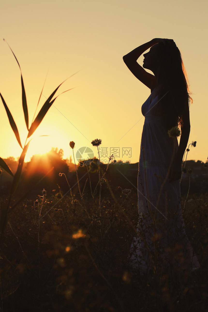 日落时田野里漂亮的轻女人照片色调风格Instagram过滤器图片