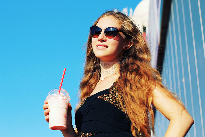 微笑时尚的金发女郎户外喝草莓奶昔照片色调风格Instagram过滤器图片