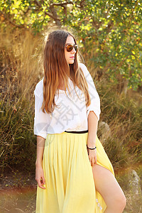 穿黄裙子女孩穿着裙子太阳镜的漂亮金发轻女人女模特穿着时髦的衣服,街上散步背景