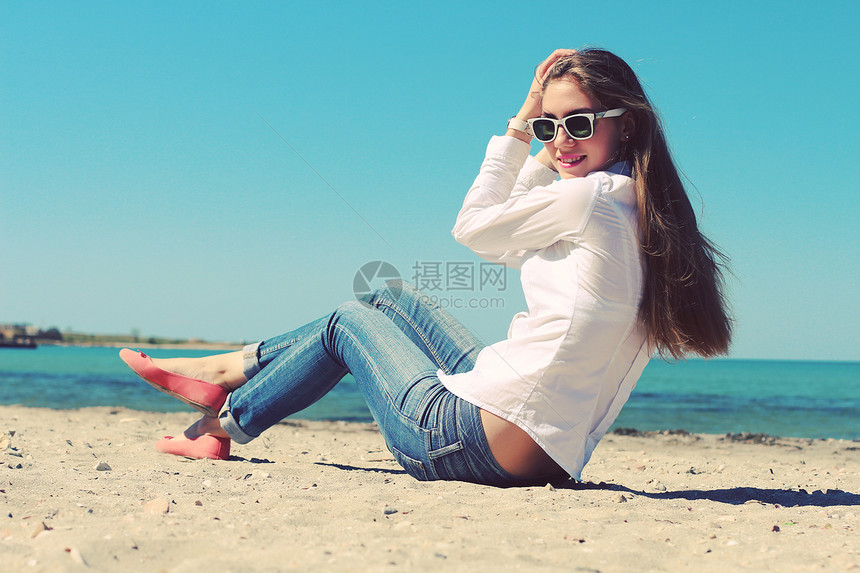 快乐的轻时尚女孩戴着太阳镜海滩上散步夏天户外,生活方式拍摄复古的颜色照片色调风格Instagram过滤器图片
