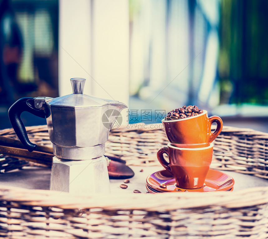 咖啡杯壶满咖啡豆花园露台桌子上的自然背景早上回家的场景图片