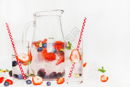 水壶与浆果夏季饮料两杯白色木制背景排饮料,饮食保健食品的图片