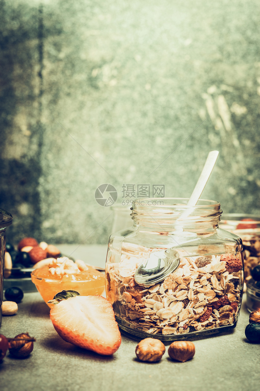 早餐场景与穆斯利罐厨房桌子上与坚果浆果乡村背景,地点为文字,复古色调图片