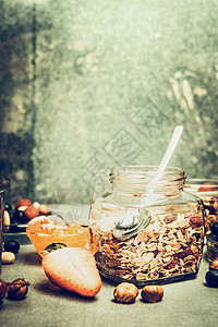 早餐场景与穆斯利罐厨房桌子上与坚果浆果乡村背景,地点为文字,复古色调图片