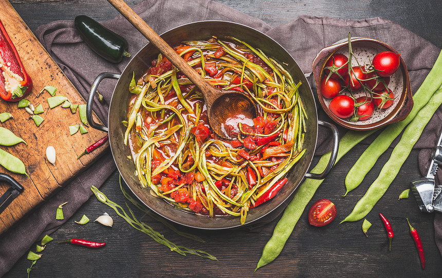 用木勺准备青法豆餐绿色法国豆烹饪锅与番茄酱配料黑暗的乡村背景,顶部的素食的图片